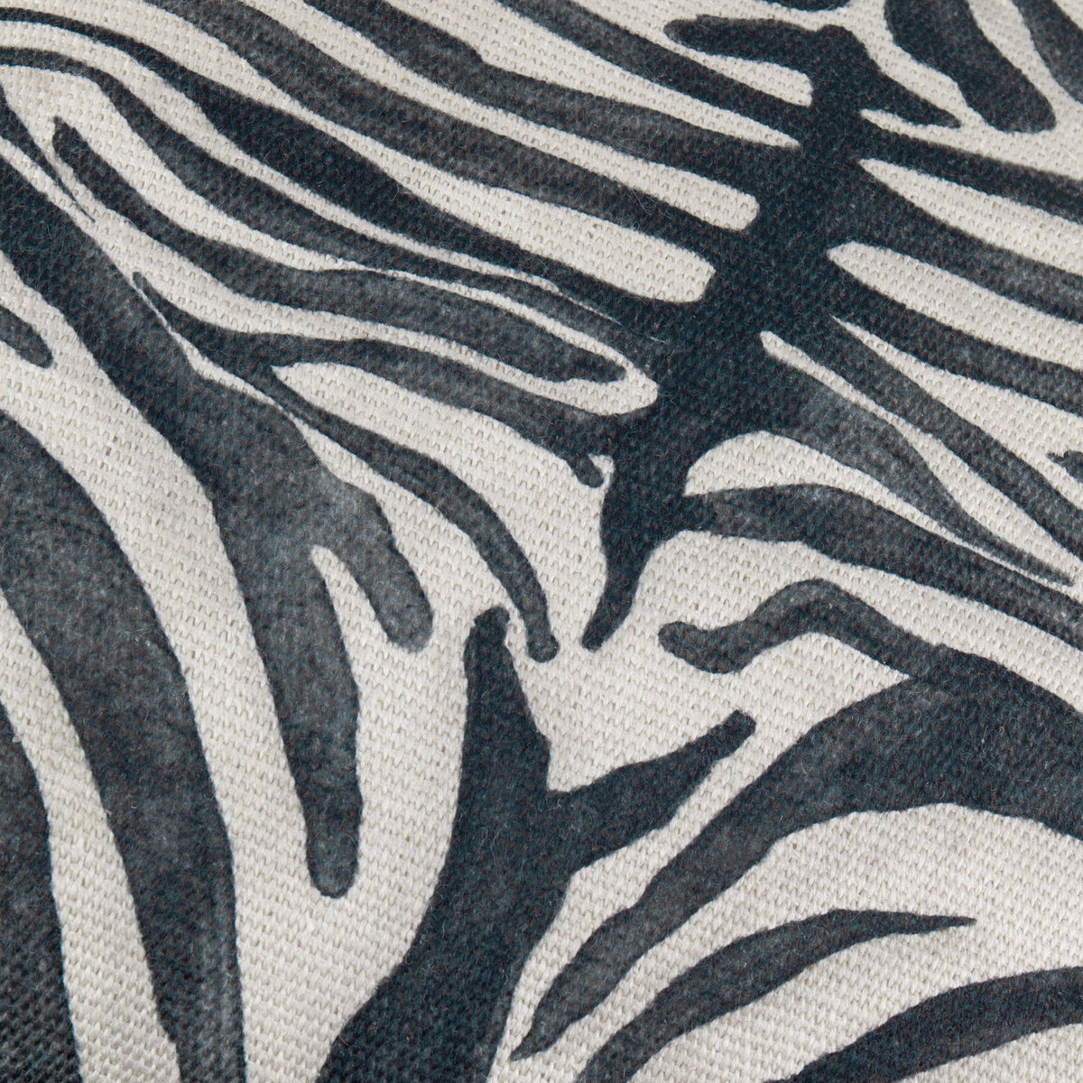 Close-up of the Leopardis cushion's woven polyester fabric, showing a bold black zebra-style print on an oatmeal ground with a textured basketweave finish.
