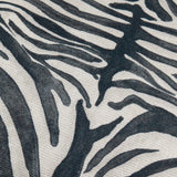Close-up of the Leopardis cushion's woven polyester fabric, showing a bold black zebra-style print on an oatmeal ground with a textured basketweave finish.
