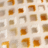Close-up of the Lexington Jacquard Velvet Cushion in gold, showing a raised woven pile diamond pattern in gold, ochre, taupe and cream on a natural fabric ground.