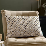 Lexington Jacquard Velvet Cushion in Warm Taupe with a diamond-patterned gold, charcoal and grey design, styled on a beige tufted armchair.