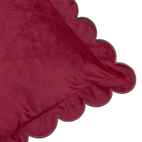 Close-up of the Lil Scallop velvet cushion in burgundy with a scalloped edge finished in contrasting chocolate-brown thread, shown on a plain white background.