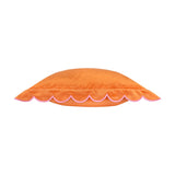 Side view of the Lil Scallop velvet cushion in orange, showing its scalloped edge trim in contrast pink thread, on a plain white background.