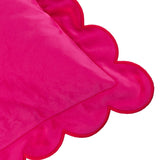 Close-up of the Lil Scallop Plain Velvet Cushion in pink, showing its scalloped edge trimmed in contrasting red thread on a plain background.