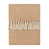 Lorne Plain Cotton Throw in honey, folded flat with a chunky waffle-weave texture and cream tassel fringe, shown on a plain white background.