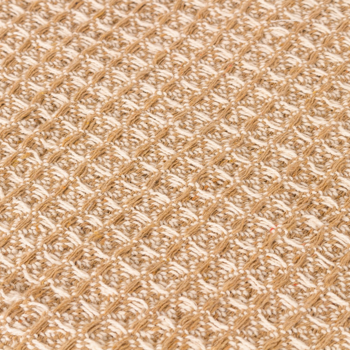 Close-up of the Lorne Plain Cotton Throw in Honey, showing a chunky two-tone waffle weave in 100% cotton with honey and pale natural yarns creating a mottled, textured grid.