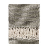 Lorne Plain Cotton Throw in Lichen, folded to show a chunky two-tone green waffle weave with cream fringed tassels, on a plain white background.