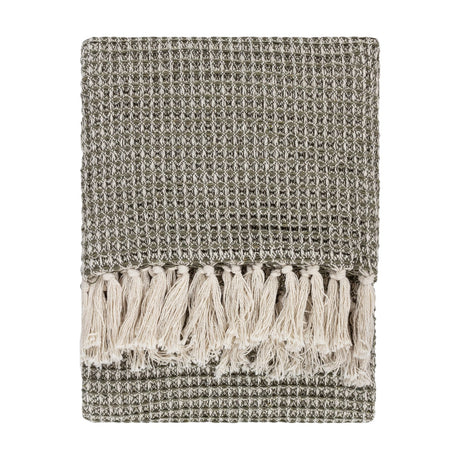 Lorne Plain Cotton Throw in Lichen, folded to show a chunky two-tone green waffle weave with cream fringed tassels, on a plain white background.