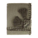 Folded Lowen wool blend throw in moss green with a brushed finish, whip-stitched edges, and decorative tassel detail, shown on a plain white background.