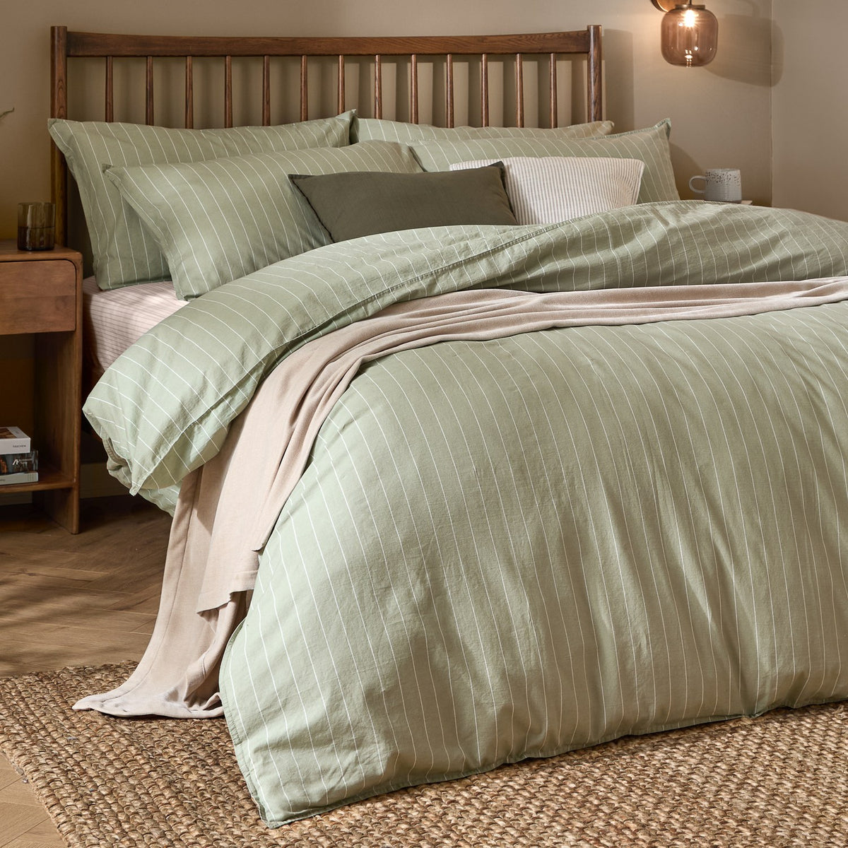 Linear Stripe Cotton Printed Duvet Cover Set in Forest, styled on a bed with matching pillowcases, dressed with cushions and a beige throw in a wooden-framed bedroom setting.