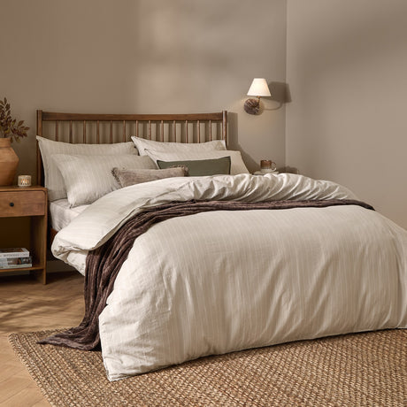 Linear Stripe Cotton Printed Duvet Cover Set in natural beige with matching pillowcases, dressed on a bed with a wooden slatted headboard in a bedroom setting.