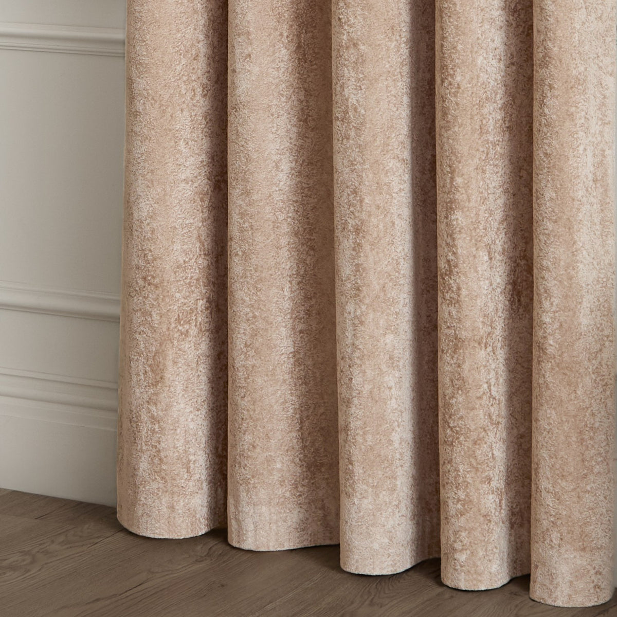 Lustre Velvet Plain Fully Lined Eyelet Curtains in Oyster, showing dense velvet pile with soft folds and eyelet heading against a panelled wall.