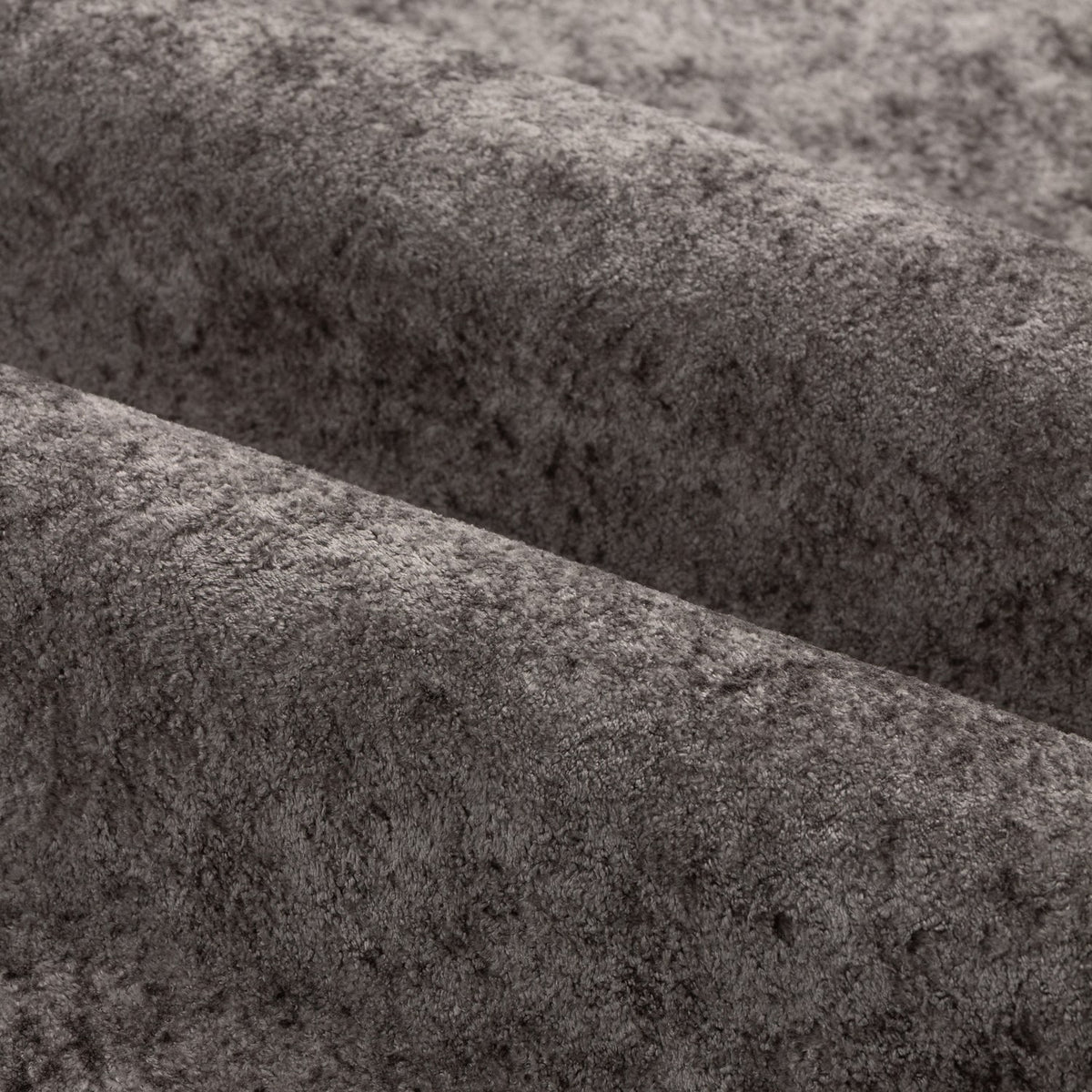 Close-up of Lustre Velvet eyelet curtain fabric in pewter grey, showing the crushed, iridescent polyester velvet texture in soft folds.