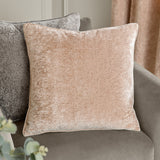 Square Lustre Velvet cushion in oyster beige with self-piped edges, shown on a grey sofa beside curtains in a living room setting.