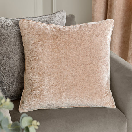 Square Lustre Velvet cushion in oyster beige with self-piped edges, shown on a grey sofa beside curtains in a living room setting.