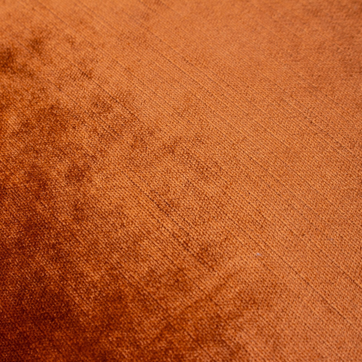 Close-up of the Luxe Velvet cushion in rust, showing the plain polyester velvet pile with a soft sheen and subtle diagonal weave texture.