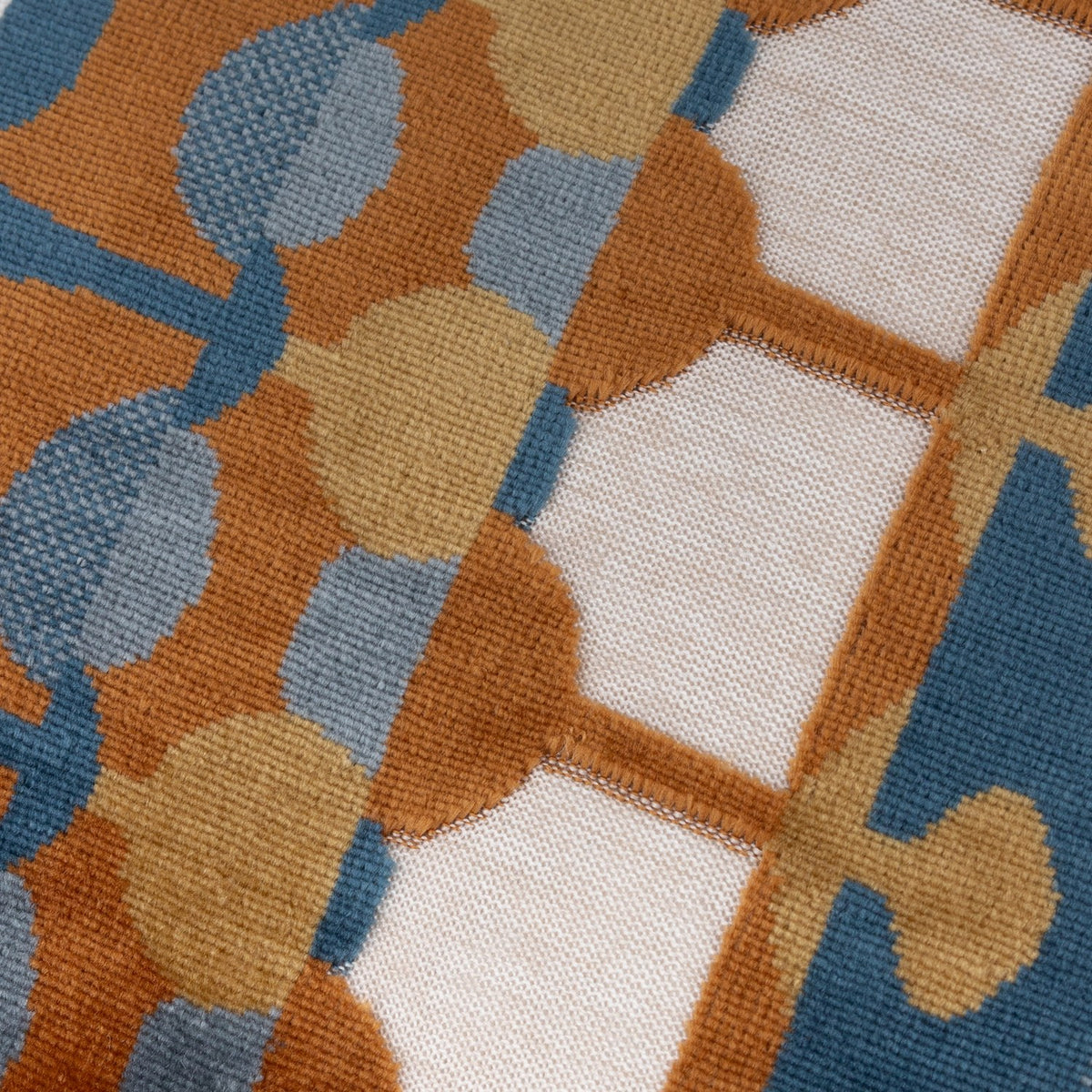 Close-up of the Metro Abstract Jacquard Velvet Cushion in Ginger, showing rust, ochre, teal and blue drop and dot shapes on a cream velvet ground.