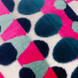 Close-up of the Metro Abstract Jacquard Velvet Cushion, showing raised velvet dots in pink, teal, navy and sage forming a geometric pattern on a cream fabric ground.