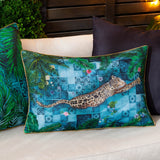 Majorelle reversible polyester cushion in azure, rectangular with a leopard printed across blue Moroccan tiles and palm fronds, shown on an outdoor sofa with cushions in the background.
