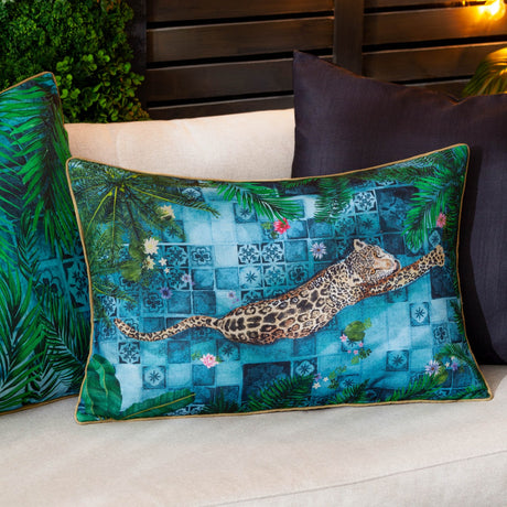 Majorelle reversible polyester cushion in azure, rectangular with a leopard printed across blue Moroccan tiles and palm fronds, shown on an outdoor sofa with cushions in the background.
