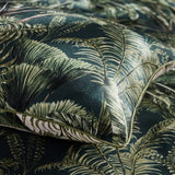 Close-up of the Majorelle Cotton Duvet Cover Set in green, showing a tropical palm and fern print with cord-piped edge trim and reversible pale underside.