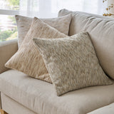 Malvern Jacquard Chenille Cushion in griege, a 45 x 45cm square textured cushion with mottled tan and cream flecks, styled on a beige sofa alongside two neutral-toned cushions.