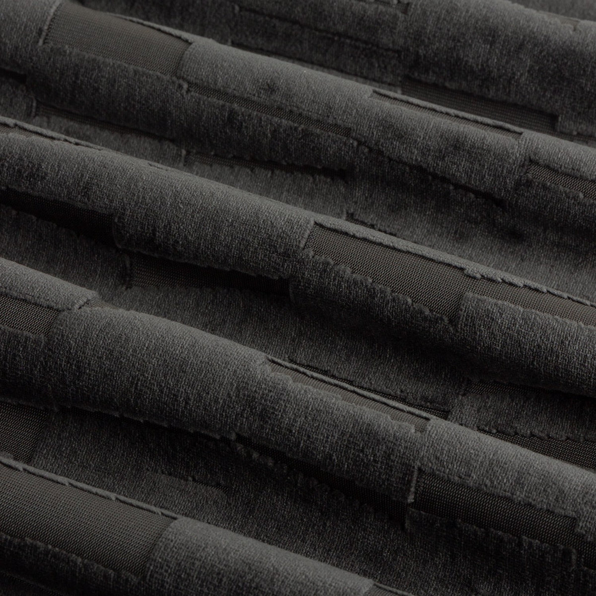Close-up of Manhattan Velvet Fully Lined Eyelet Curtains in charcoal, showing cut-pile velvet fabric with a textured geometric block pattern and soft fold detail.