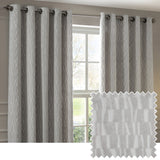 Manhattan Velvet Fully Lined Eyelet Curtains in silver grey, hung on a rod either side of a window, with a fabric swatch showing the raised geometric block pattern.