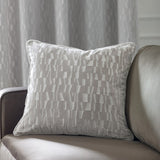 Manhattan Geometric Velvet Cushion in silver with cut velvet geometric pattern, shown on a grey sofa in a living room setting.