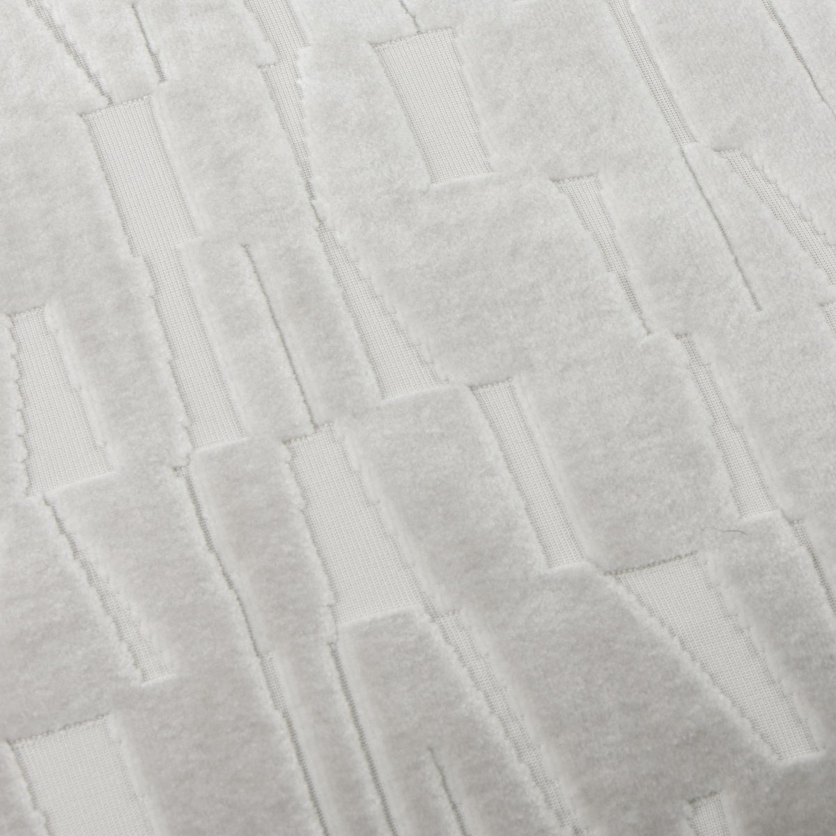 Close-up of the Manhattan Geometric Velvet Cushion in silver, showing a cut-velvet block and bar pattern with raised pile against a flatter woven ground.