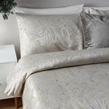 Marble Jacquard Abstract Duvet Cover Set in Oyster with swirling metallic-look pattern, styled with matching pillowcases and a grey textured cushion on a bed.