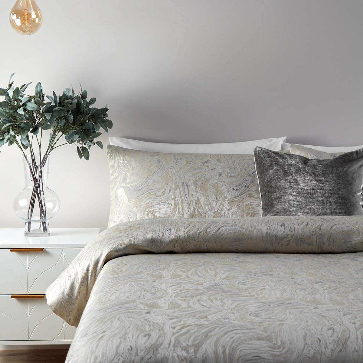 Marble Jacquard Abstract Duvet Cover Set in Oyster on a bed with matching pillowcase and velvet cushions, styled in a bedroom with a plant and pendant light.