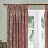 Marigold Jacquard pencil pleat curtains in russet, showing a foliage and sunburst floral pattern woven in polyester, hung on a wooden pole beside a white-framed window.