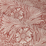 Close-up of Marigold jacquard pencil pleat curtain fabric in russet, showing woven foliage and sunburst floral pattern in polyester with folds highlighting the raised texture.