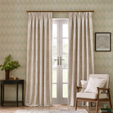 Marigold Jacquard pencil pleat curtains in stone, hung floor-length either side of French doors in a living room with patterned wallpaper and a beige armchair.