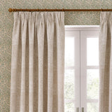 Marigold Jacquard pencil pleat curtains in stone, woven with a raised floral and foliage pattern, shown pleated on a wooden pole beside a white French door.