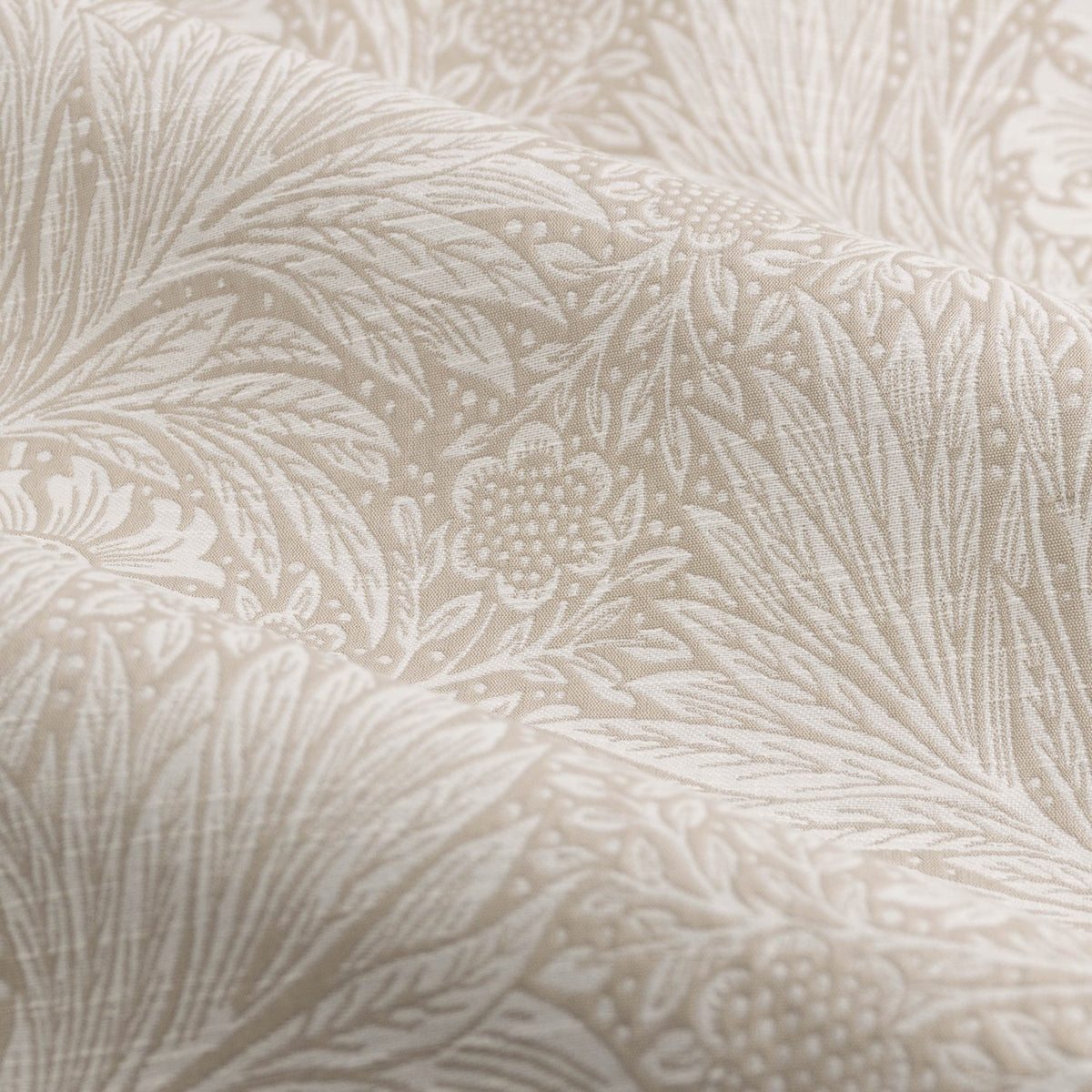 Close-up of Marigold Jacquard pencil pleat curtains in stone, showing woven leaf and sunburst floral pattern in raised jacquard texture on 100% polyester fabric.