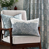 Rectangular Marigold cushion with cream floral jacquard pattern on ivory linen, navy piped edges, styled on a beige armchair with matching patterned curtains.