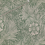 Marigold Jacquard Cotton Throw in Leaf Green, folded to show reversible woven pattern with green florals on cream and cream motifs on green, fringed edge visible.