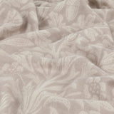 Marigold Jacquard Cotton Throw in Stone, close-up of the draped fabric showing a tonal woven leaf, acorn and bloom pattern in soft beige.
