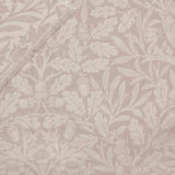 Marigold Jacquard Cotton Throw in Stone, close-up of woven leaf, acorn and floral pattern in tonal beige with a fringed edge visible.