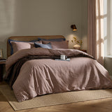 Marlow Stripe Cotton Printed Duvet Cover Set in cocoa/vintage blue on a bed with rattan headboard, styled with navy pillowcases in a bedroom setting.