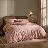 Marlow Stripe Cotton Printed Duvet Cover Set in maple and sandalwood tones dressed on a bed with matching pillowcases and a beige throw in a bedroom setting.