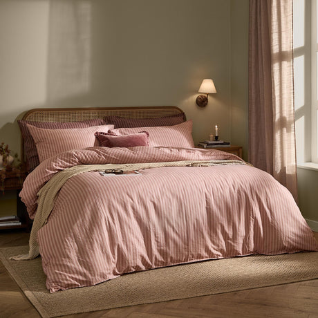Marlow Stripe Cotton Printed Duvet Cover Set in maple and sandalwood tones dressed on a bed with matching pillowcases and a beige throw in a bedroom setting.