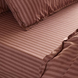 Marlow Stripe Printed Cotton Fitted Sheet in Chocolate/Rosewood, shown fitted to a mattress with matching pillowcase, in a tonal striped cotton finish.