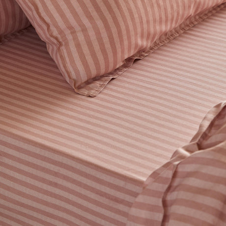 Marlow Stripe Printed Cotton Fitted Sheet in Maple/Sandalwood, showing pure cotton fabric with a muted pink striped pattern, styled with a matching pillowcase.