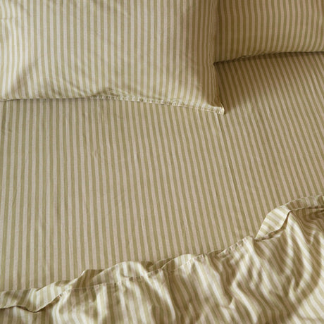 Marlow Stripe Printed Cotton Fitted Sheet in Oregano/Shell, shown on a made bed with matching striped pillowcases in soft green and cream tones.