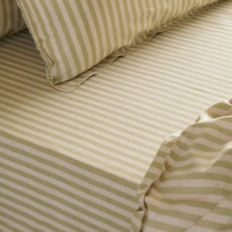 Marlow Stripe Printed Cotton Fitted Sheet in Oregano/Shell, close-up on a bed showing the green and cream striped fitted sheet with matching pillowcase.