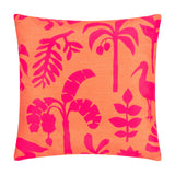 Marula Jungle polyester cushion in coral-orange with a bold pink tropical print of palm trees, banana leaves, ferns and a wading bird, shown square on a plain white background.