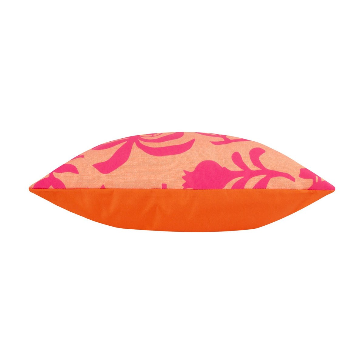 Marula Jungle polyester cushion shown side-on, revealing coral-orange piped edge and pink tropical leaf print on a coral ground, plain white background.