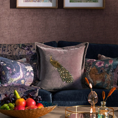 Mayura Animal Velvet Cushion in lavender velvet with an embroidered gold-thread peacock and beaded tail, shown on a navy sofa with patterned cushions.